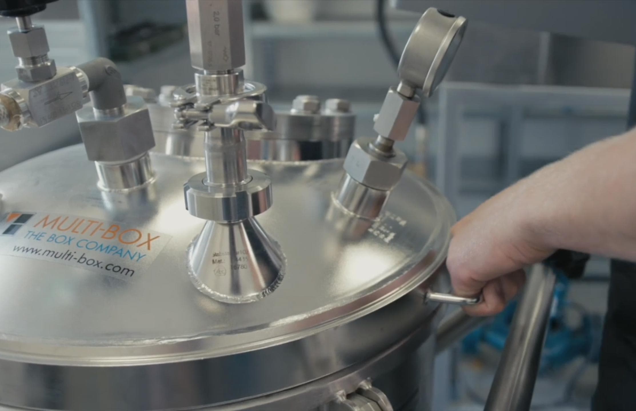 Ein Edelstahl-Tauchbecken mit mehreren Anschlüssen und Schläuchen wird für Dichtigkeitstests verwendet.